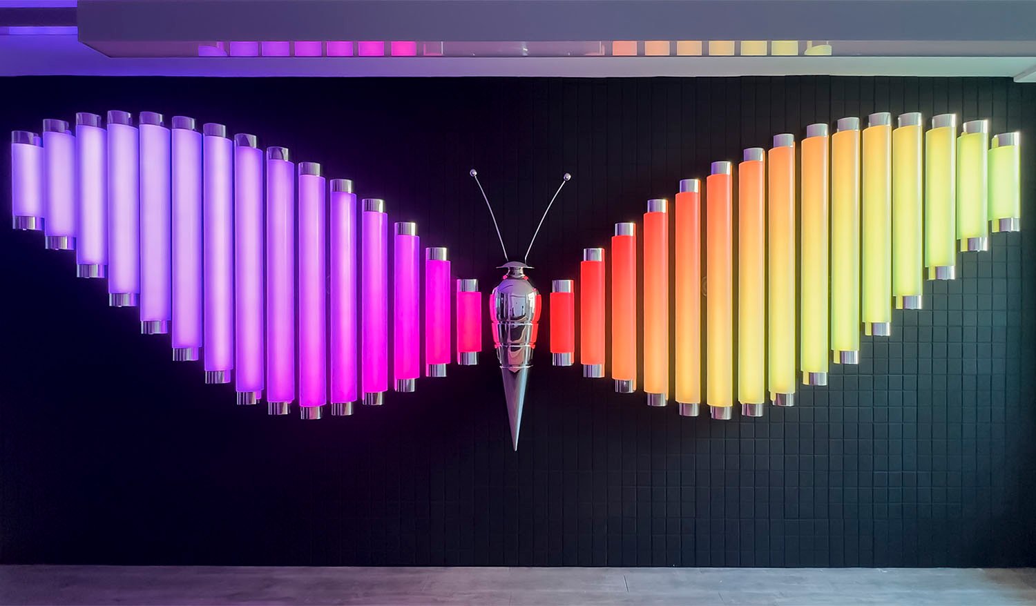 Interactive Butterfly light installation with colorful illuminated tube wings and a metallic butterfly sculpture at the center.